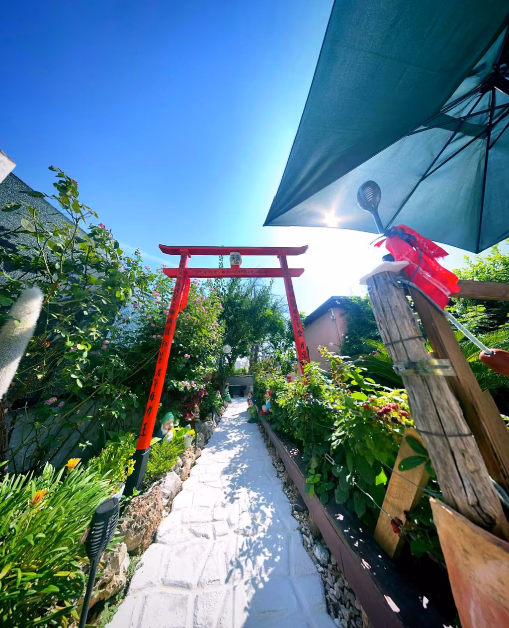 Il cancello rosso e l'ombrellone nel giardino del Far West B&B
